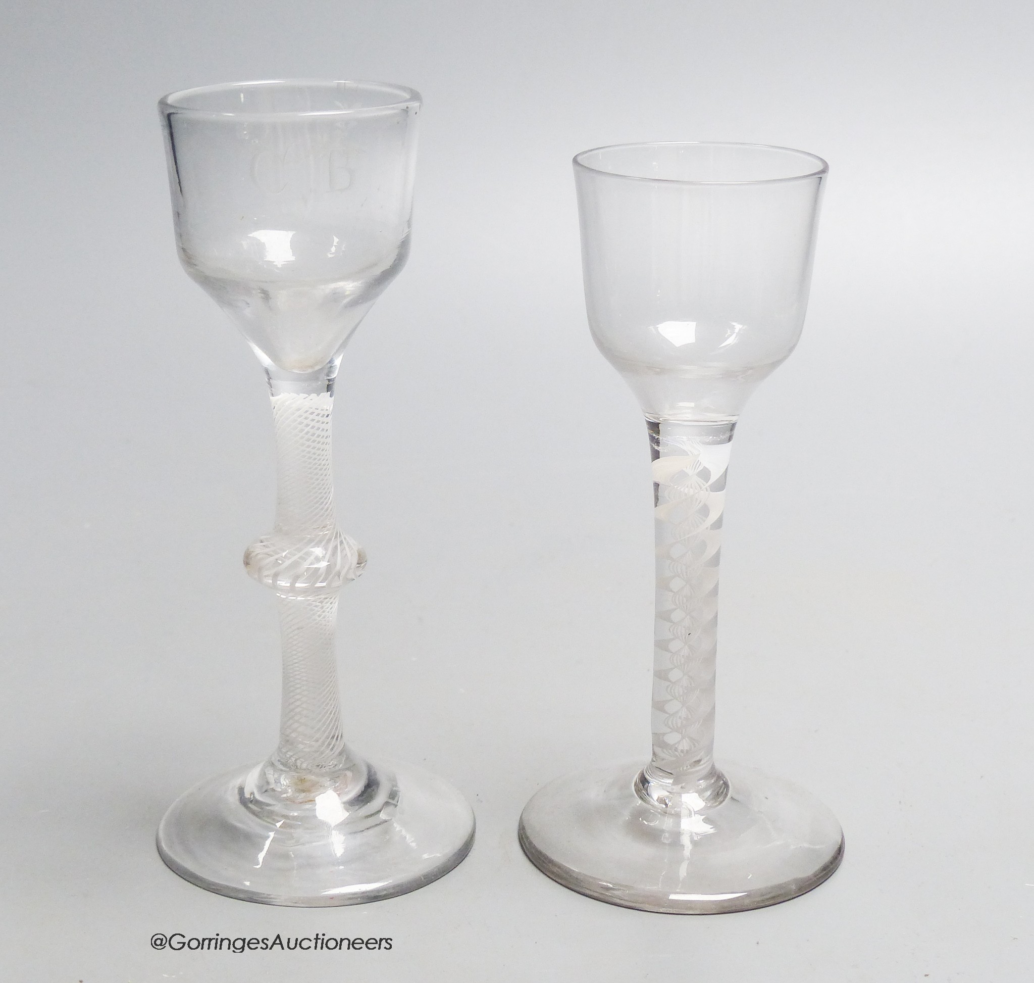 Two Georgian opaque twist stem cordial glasses, each with a funnel bowl, one engraved C B with dove and olive branch, tallest 15cm